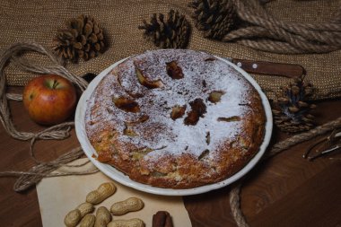 Ev yapımı turta. Elmalı turta üzerine şekerleme serpiştirilmiş. Sonbahar arkaplanda turta. Sonbahar hamur işleri