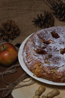 Ev yapımı turta. Elmalı turta üzerine şekerleme serpiştirilmiş. Sonbahar arkaplanda turta. Sonbahar hamur işleri