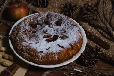 Ev yapımı turta. Elmalı turta üzerine şekerleme serpiştirilmiş. Sonbahar arkaplanda turta. Sonbahar hamur işleri
