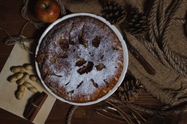 Ev yapımı turta. Elmalı turta üzerine şekerleme serpiştirilmiş. Sonbahar arkaplanda turta. Sonbahar hamur işleri