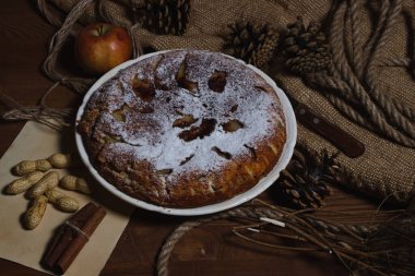 Ev yapımı turta. Elmalı turta üzerine şekerleme serpiştirilmiş. Sonbahar arkaplanda turta. Sonbahar hamur işleri