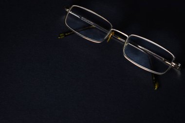 Siyah arka planda gözlük. Zarif bir tarz. Yazıt ya da logo için bir yer var..