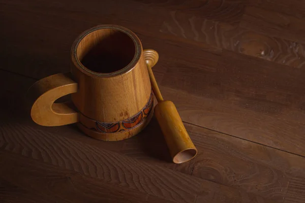 Wooden mug on a wooden table. Wooden dishes. Antique dishes.