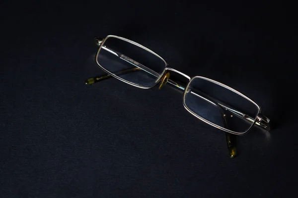 Glasses on a black background. Elegant style. There is a place for an inscription or logo.