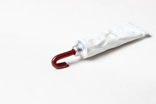 Tubo Tinta Vermelha Sobre Fundo Branco Tinta Espremida Para Fora — Fotografia de Stock