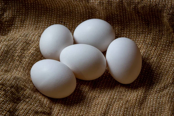 White chicken eggs. White eggs lie on sacking
