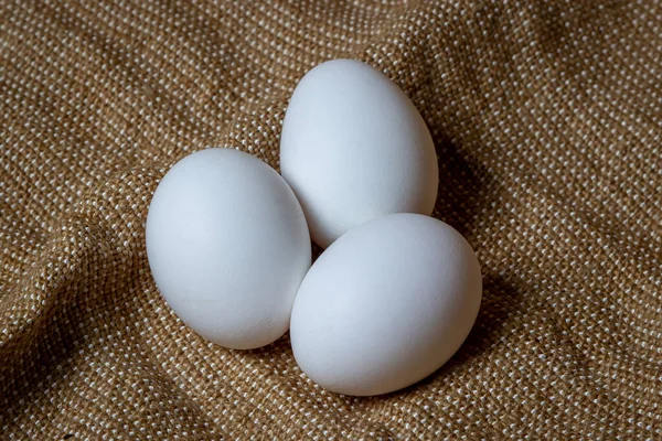 White chicken eggs. White eggs lie on sacking