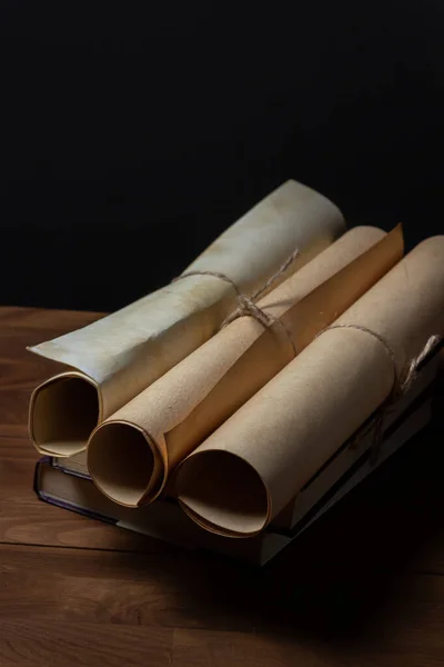 Old scrolls and books on a black background. Education concept.