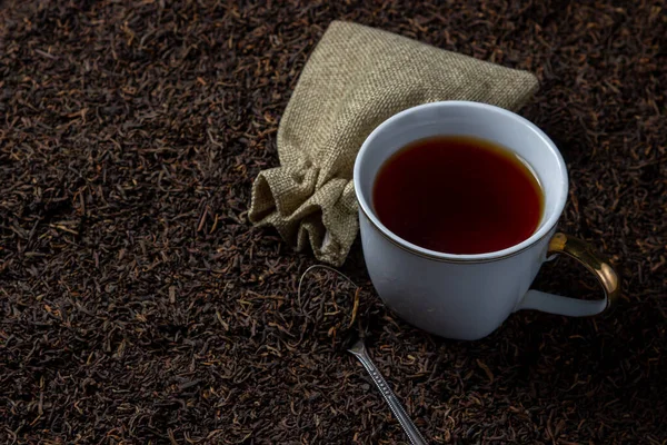 お茶が甘いわね 茶のカップが茶葉の上に立つ — ストック写真