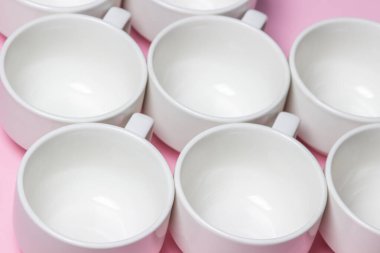 Pembe arka planda beyaz bardaklar. Bir sürü boş çay bardağı..
