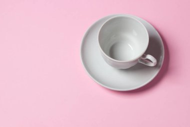 Pembe arka planda bir kahve fincanı. Kahve fincanı ve çay tabağı..