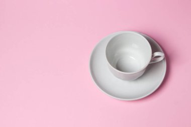 Pembe arka planda bir kahve fincanı. Kahve fincanı ve çay tabağı..