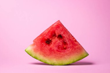 Pembe arka planda karpuz. Bir dilim karpuz kes. Olgun kırmızı karpuz