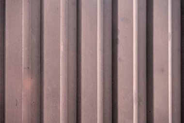 Oluklu metal levha çit görevi görüyor, dikey çizgilere yatay görünüm