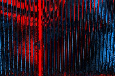 Boyalı ve kıvrımlı metal levhalar çit görevi görür, dikey çizgilere yatay görünüm