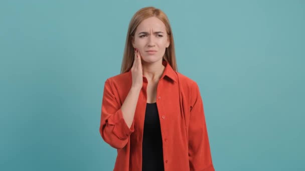 Jonge vrouw geïsoleerd op turquoise achtergrond die lijden aan ernstige kiespijn. — Stockvideo