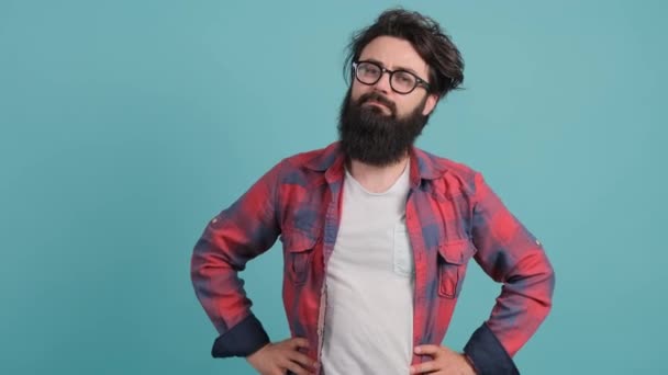 Fiatal szakállas férfi türkiz háttér mutatja hüvelykujj lefelé gesztus a kamera. — Stock videók