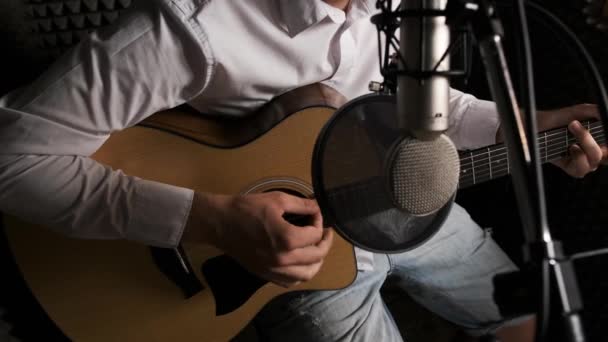 Detailní záběr mladého kytaristy, který nahrává novou píseň ve zvukovém studiu. — Stock video