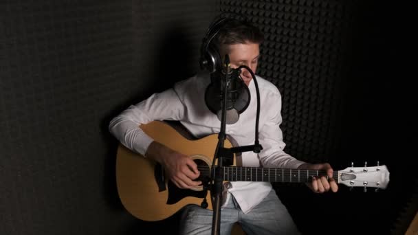 Modern bir ses stüdyosunda yeni şarkı kaydeden genç bir müzisyen.. — Stok video