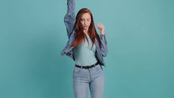 Retrato mujer feliz bailando y moviendo sus manos sobre fondo turquesa. — Vídeo de stock