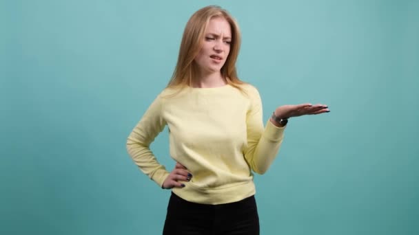 Vrouw geïsoleerd over turquoise achtergrond ongelukkig voor niet begrijpen iets. — Stockvideo