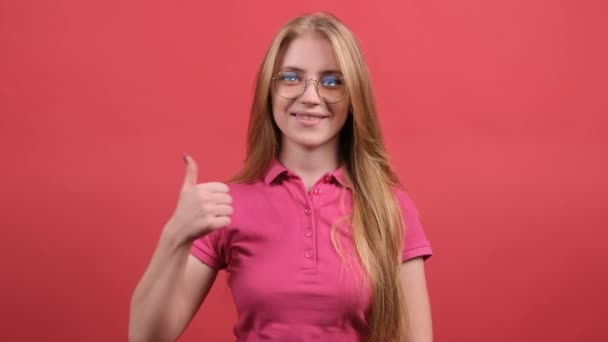 Portrét atraktivní mladé ženy ukazující palce nahoru na červeném pozadí — Stock video