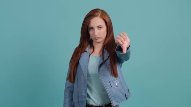 Retrato de una joven descontenta haciendo un gesto de pulgares hacia abajo. — Vídeos de Stock