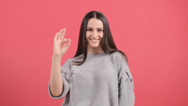 Mujer joven feliz mostrando signo ok con los dedos aislados sobre un fondo rojo. — Vídeos de Stock