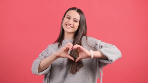 Happy woman put make with fingers heart shape, isolated over red background. — Stock Video