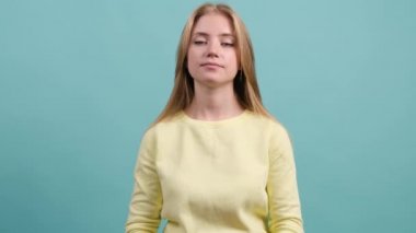 Alkışlayan genç güzel kız, turkuaz arka planda alkışlıyor..