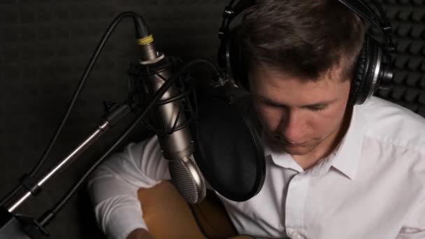 Bir ses stüdyosunda yeni şarkı kaydeden genç bir müzisyen.. — Stok video