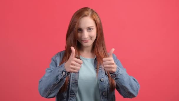 Beautiful woman showing thumbs up, isolated over a red background. — Stock Video