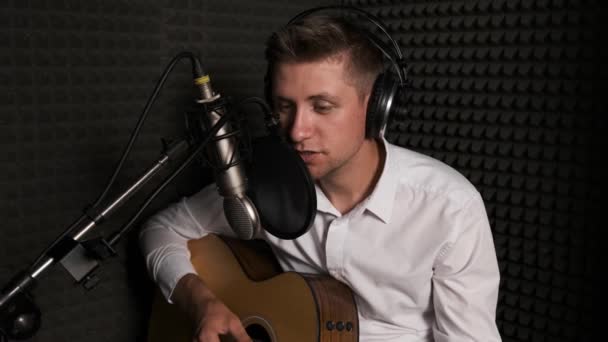 Jeune musicien qui enregistre une nouvelle chanson dans un studio sonore moderne. — Video