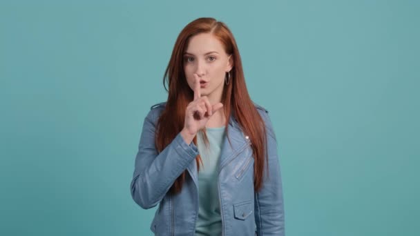 Mädchen zeigt mit Finger ruhig zu sein, isoliert auf rotem Hintergrund. — Stockvideo