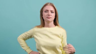 Turkuaz arka planda izole edilmiş bir kadın bir şeyi anlamadığı için mutsuz..