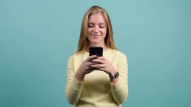 Akıllı telefon kullanan mutlu genç bir kadın. Şaşırmış bir kız telefonunda mesaj atıyor..