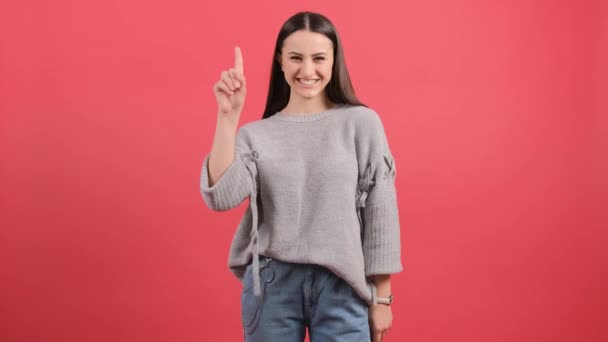 Jonge vrouw toont en steekt een vinger uit als een teken van het beste idee — Stockvideo