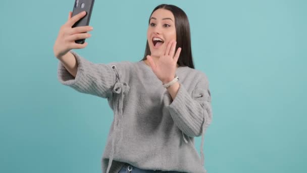 Mujer joven saluda a amigos durante la conversación en línea. — Vídeos de Stock
