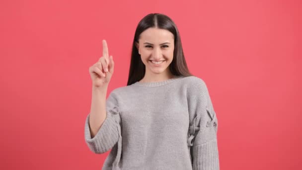 Молодая женщина показывает и поднимает палец в знак лучшей идеи — стоковое видео