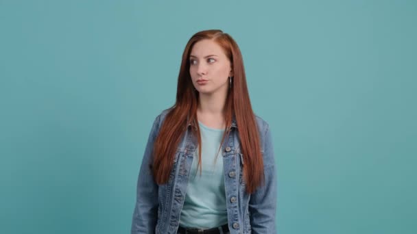 Jonge verveelde vrouw bla bla gebaar met de hand, geïsoleerd op turquoise achtergrond. — Stockvideo