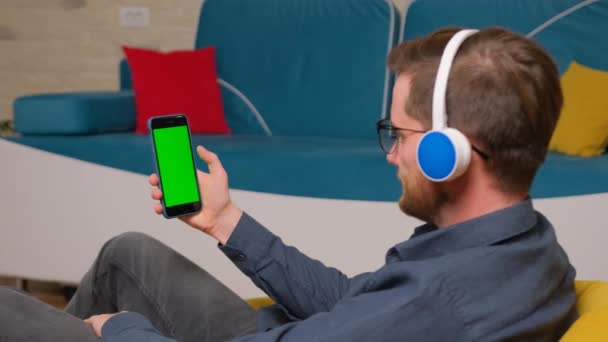 De man gebruikt een smartphone met een groen scherm model. — Stockvideo