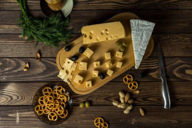 Çerez, çerez ve tuzlu bir peynir tabağını eski siyah ahşap bir masada tatmak. Şarap ve romantizm için yemek, peynir lezzetleri. Menü tasarımı yatay. Yukarıdan görüntüle.