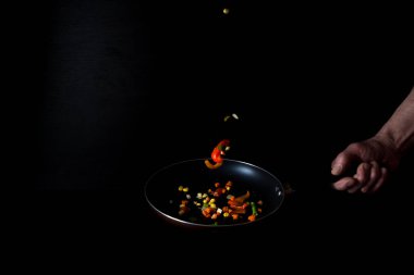 dondurucu hareket. Sebzeler bir tavada, sade bir anahtarda. Vejetaryen yemekleri pişirmek. tatlı biber, mısır, bezelye, soğan, jalapeno, kuşkonmaz fasulyesi. Reklam afişi. Otel, restoran menüsü tasarım konsepti.