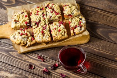 Tahtada böğürtlenli ev yapımı rendelenmiş turta. Hibiscus şeffaf bir bardakta içer. Kırmızı frenk üzümü, siyah frenk üzümü, bektaşi üzümü..