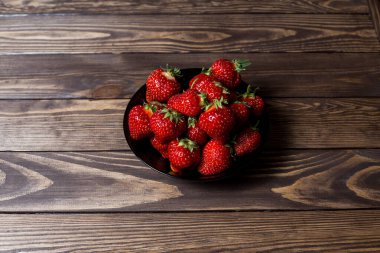 Taze, olgun çilekler masada bir tabakta.
