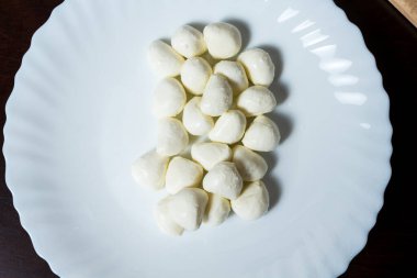 Beyaz tabakta mini mozzarella peyniri topları. menü tasarımı kavramı.