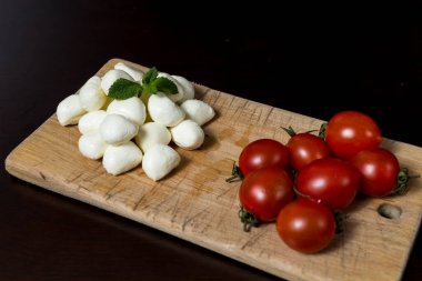 Tahta üzerinde mini mozarella peyniri ve vişneli domates topları. menü tasarımı kavramı.