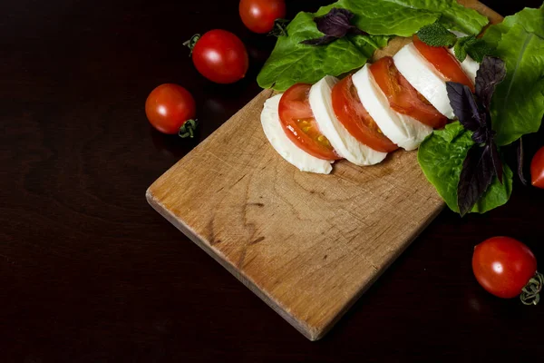 Voedselachtergrond Gesneden Mozzarella Kaas Gesneden Tomaat Een Houten Plaat Met — Stockfoto