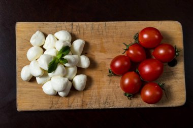 Tahta üzerinde mini mozarella peyniri ve vişneli domates topları. menü tasarımı kavramı.