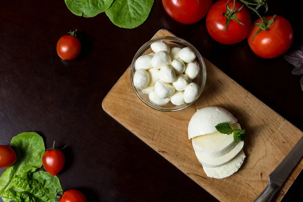 Voedselachtergrond Gesneden Mozzarella Kaas Gesneden Tomaat Een Houten Plaat Met — Stockfoto